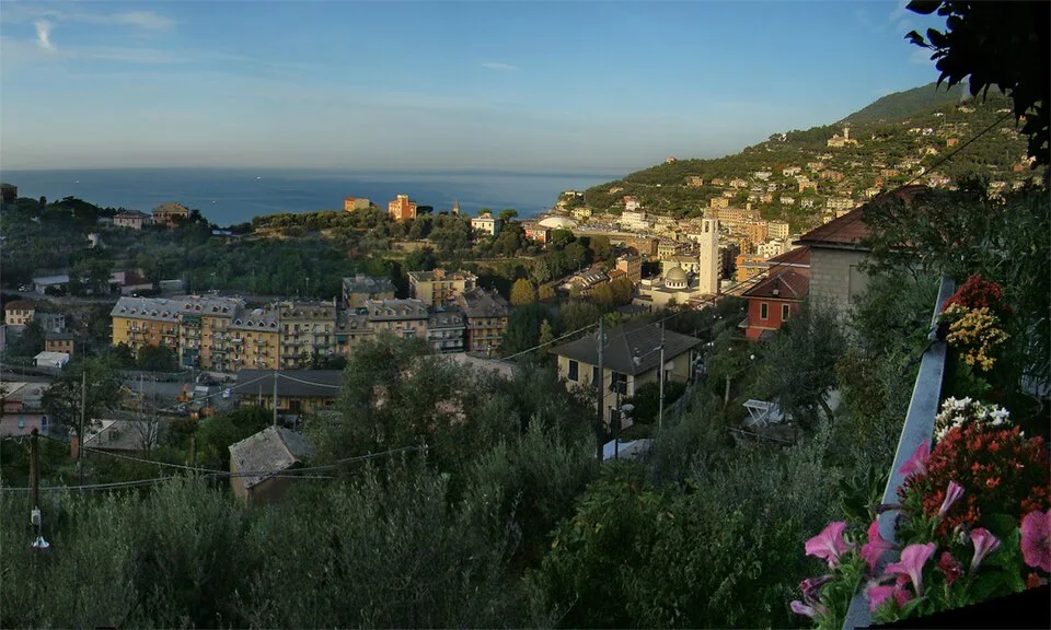 Veduta del borgo di Recco al sorgere del sole con le case che si rispecchiano nel mare del Golfo Paradiso