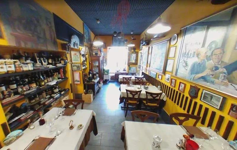 L'interno caratteristico del ristorante Cucù a Camogli, con oggetti d'epoca e tavoli apparecchiati