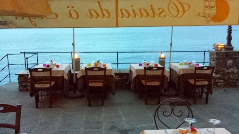 I tavoli all'aperto di Ostaia da ö Sigù affacciati sul mare di Camogli al tramonto