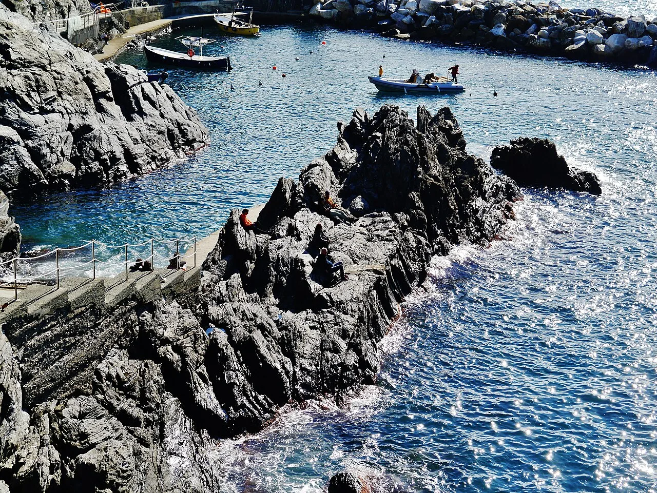 Porto di Manarola con barche colorate e riflessi sull'acqua