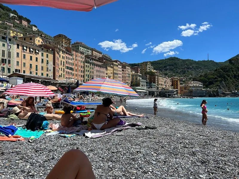 La spiaggia Base Mare RNC a Camogli, con i lettini sui ciottoli davanti alla basilica sul mare