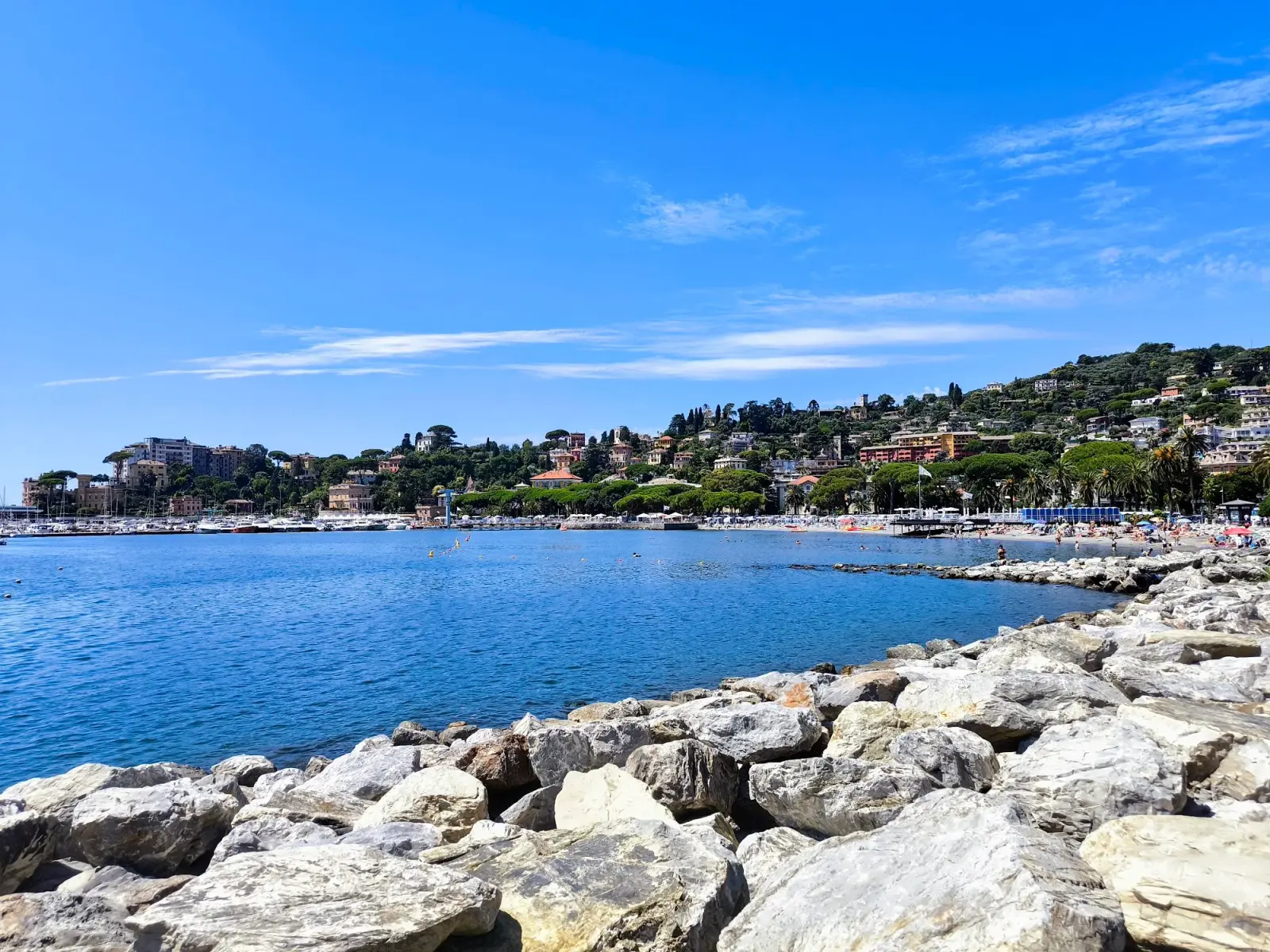 Panorama del lungomare di Rapallo visto dalla spiaggia, con il mare e le case sul fronte acqua