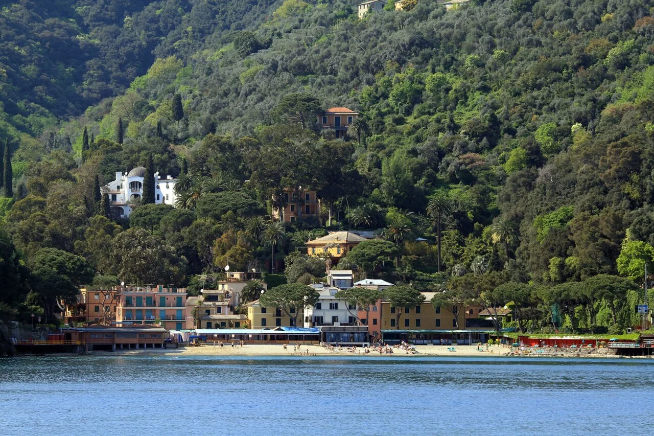 La baia di Paraggi vista dal mare, con la spiaggia di sabbia dorata, i pini marittimi e le acque trasparenti del Golfo del Tigullio