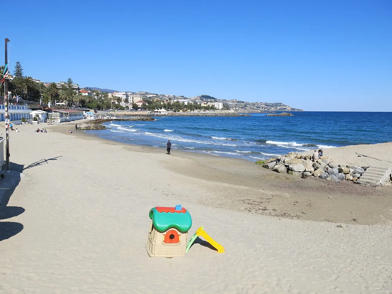 La spiaggia di Sanremo vista dal basso, con la riva sassosa e il mare calmo