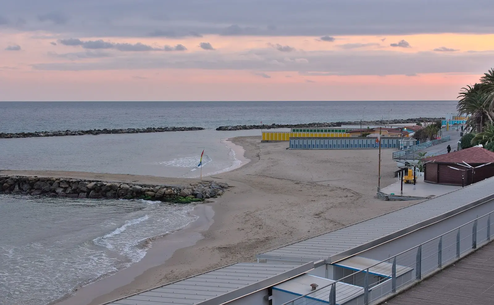 Spiaggia di Sanremo con le colline sullo sfondo e il mare calmo d'inverno