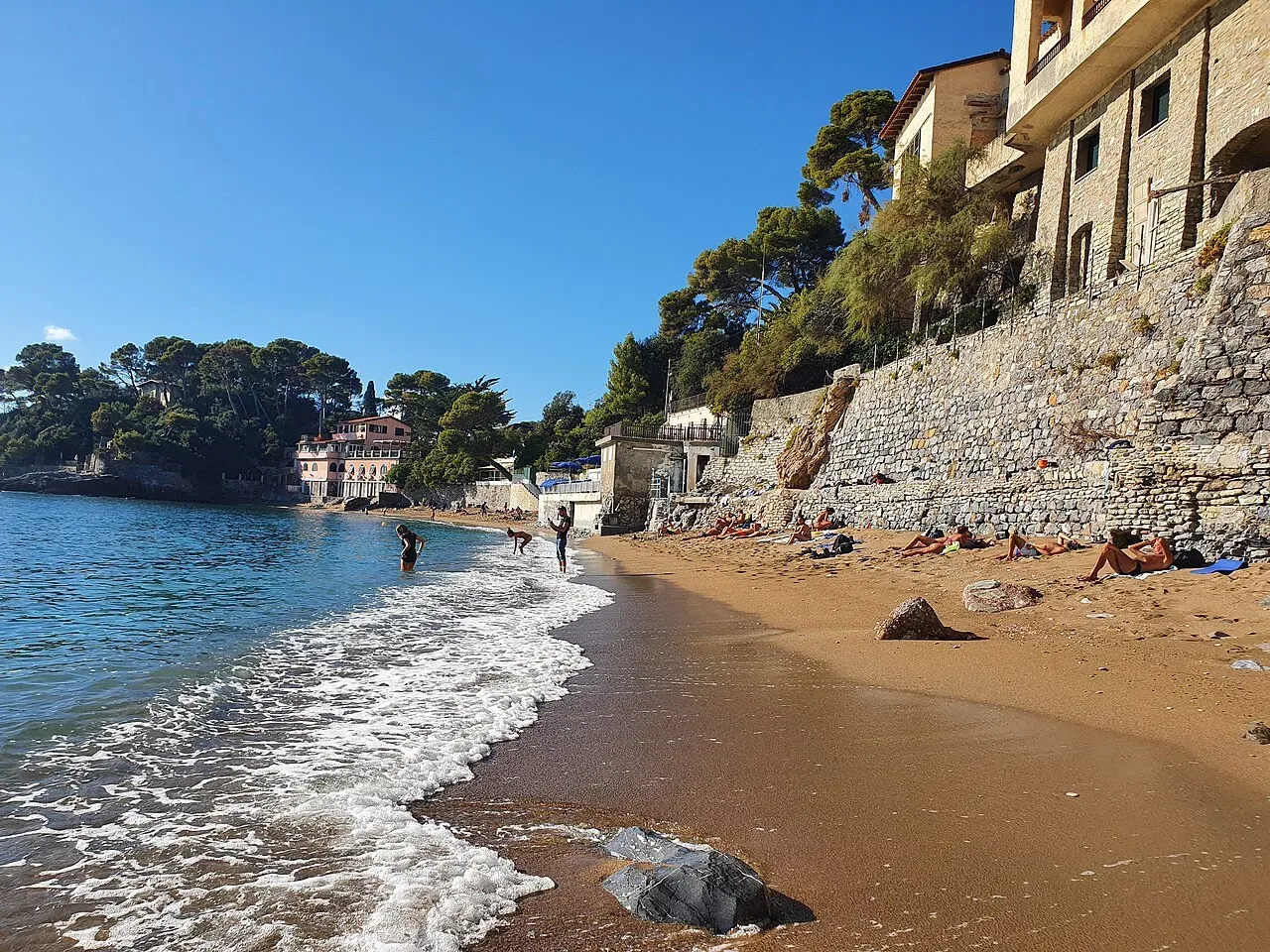 Spiaggia nella baia di Fiascherino a Lerici, con acque cristalline e sabbia fine circondati da vegetazione mediterranea
