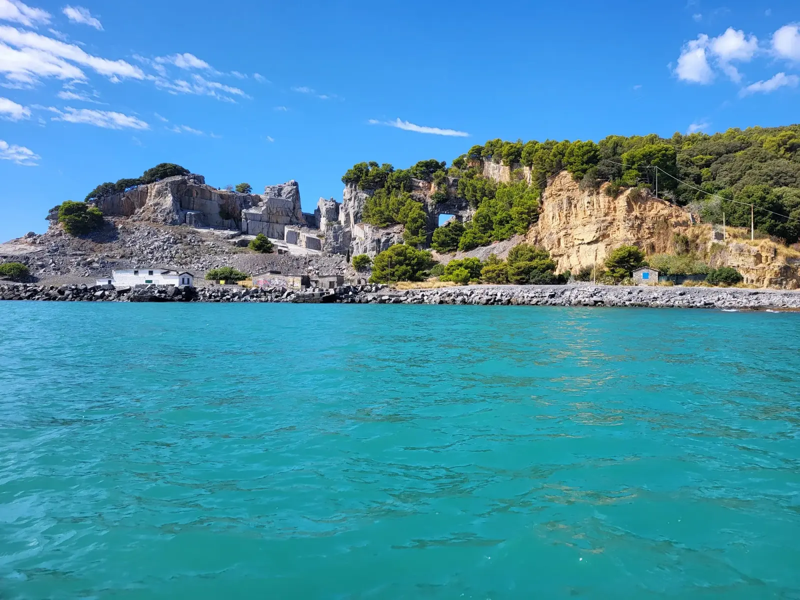 Vista sull'isola Palmaria dal mare, con la vegetazione mediterranea sulle scogliere e l'acqua limpida del Golfo della Spezia
