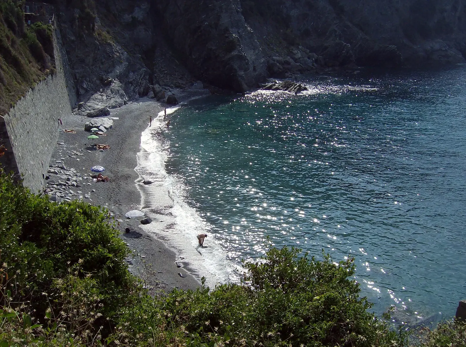 La spiaggia di Guvano vista dalla riva: sassi e acqua turchese nella baia tra Corniglia e Vernazza