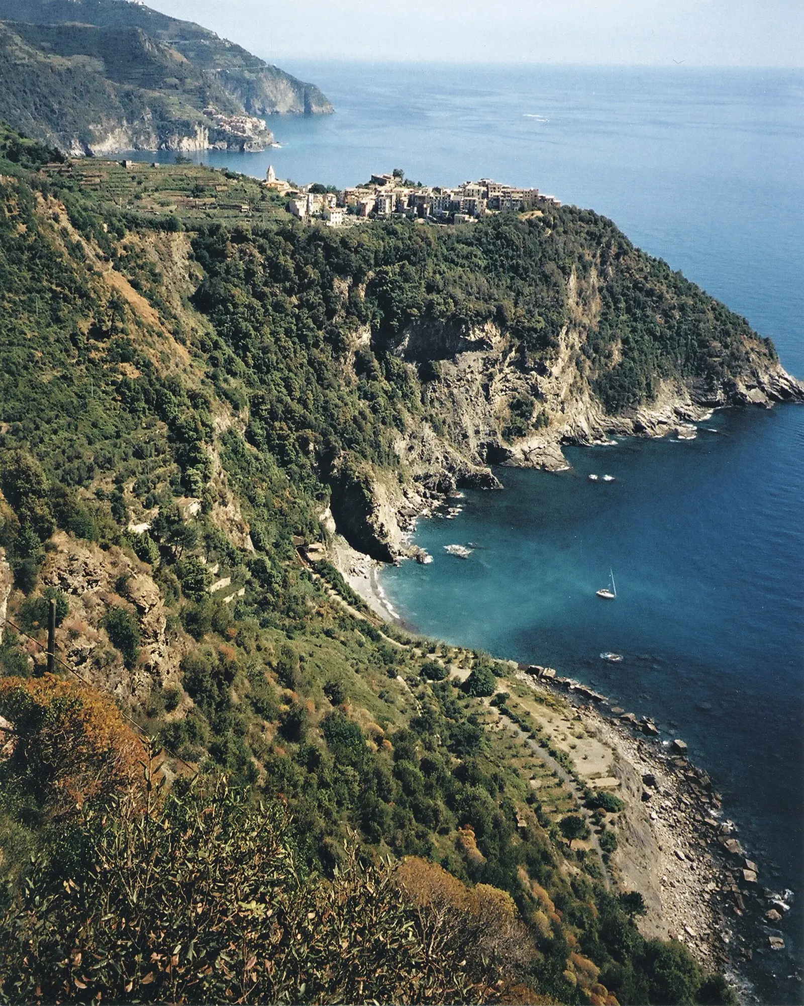Il borgo di Corniglia arroccato sul promontorio, con la baia di Guvano visibile in basso a destra