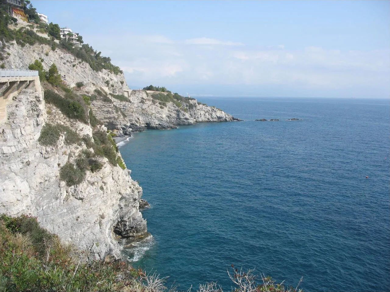 Le falesie calcaree della costa di Bergeggi a picco sul mare, con una caletta di ciottoli alla base