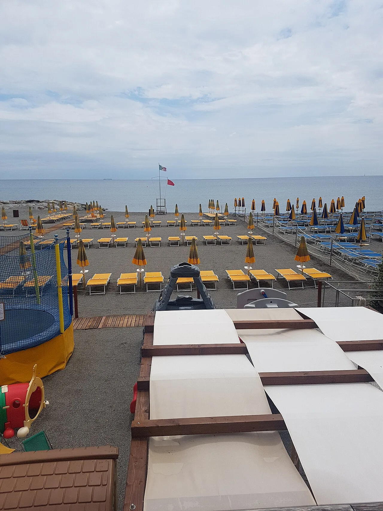 La spiaggia attrezzata di Loano con ombrelloni e sdraio sulla sabbia, vista verso il mare