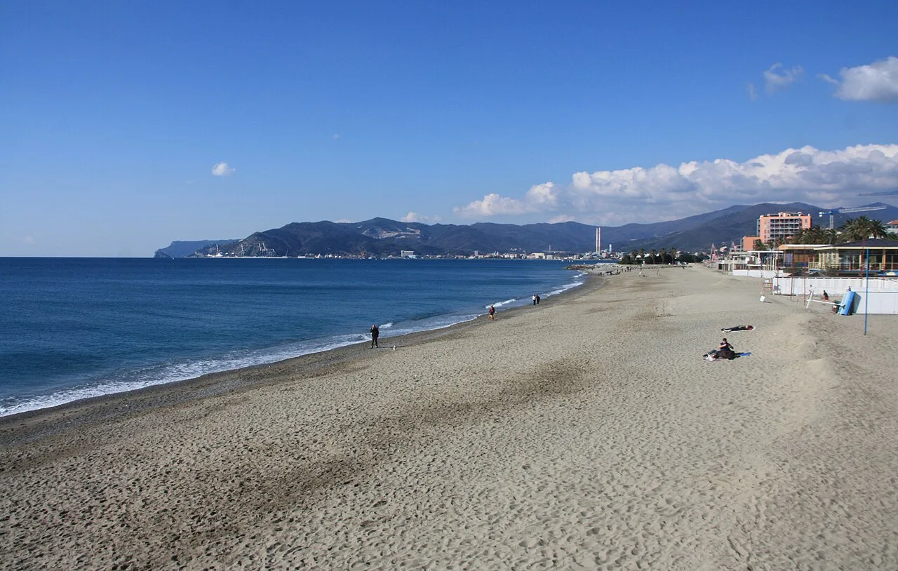 La spiaggia del Prolungamento a Mare a Savona, con la sabbia dorata e il mare limpido davanti alla Fortezza del Priamar