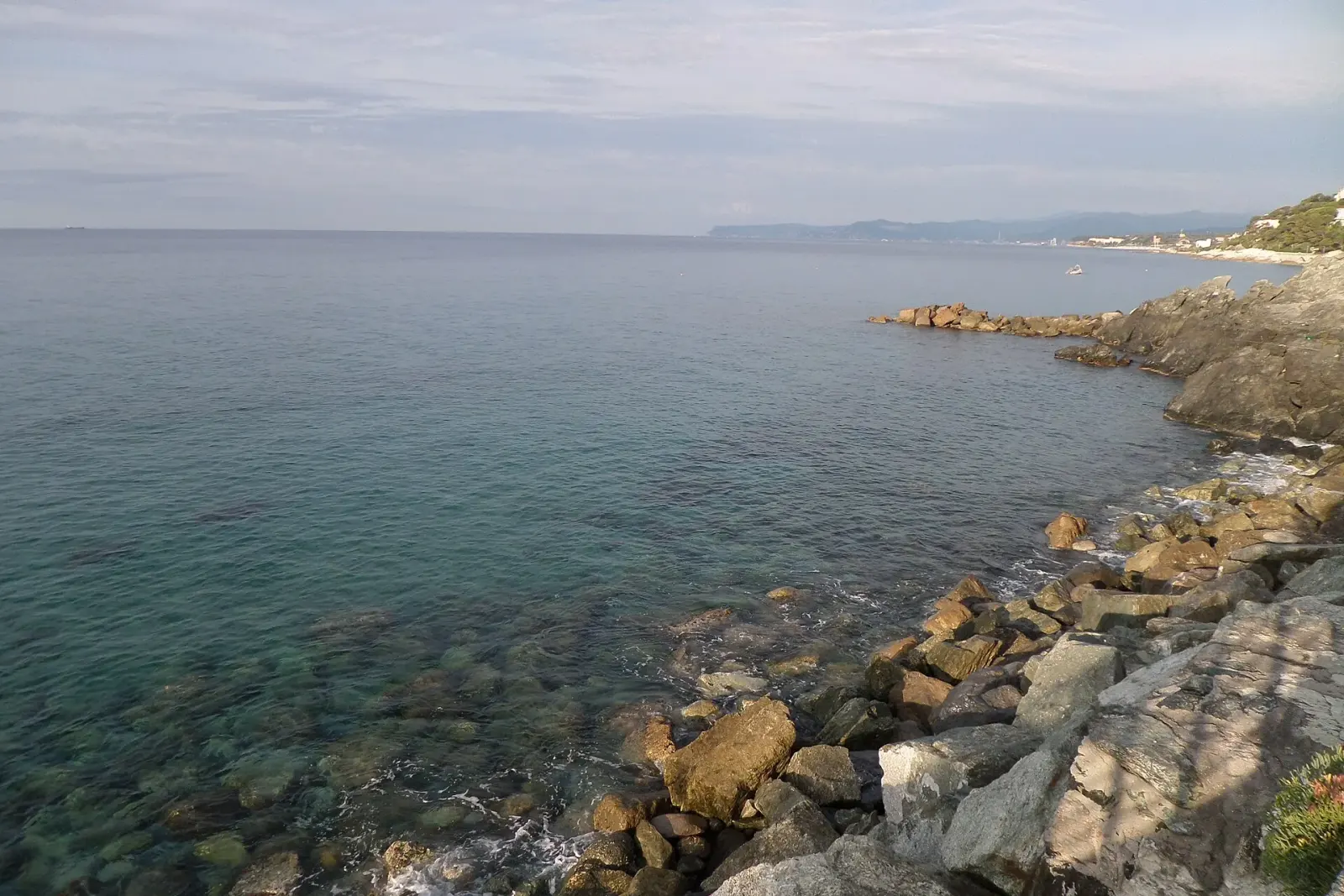 Scogliera e acqua limpida lungo il Lungomare Europa a Varazze, con la linea di costa sullo sfondo
