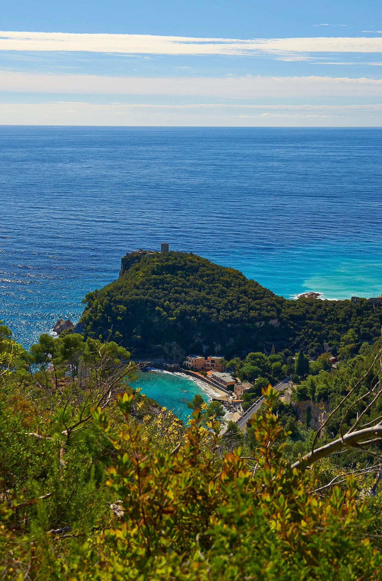 Il promontorio di Punta Crena visto dall'alto, con la Torre Saracena sulla sommità e l'acqua turchese ai piedi della falesia