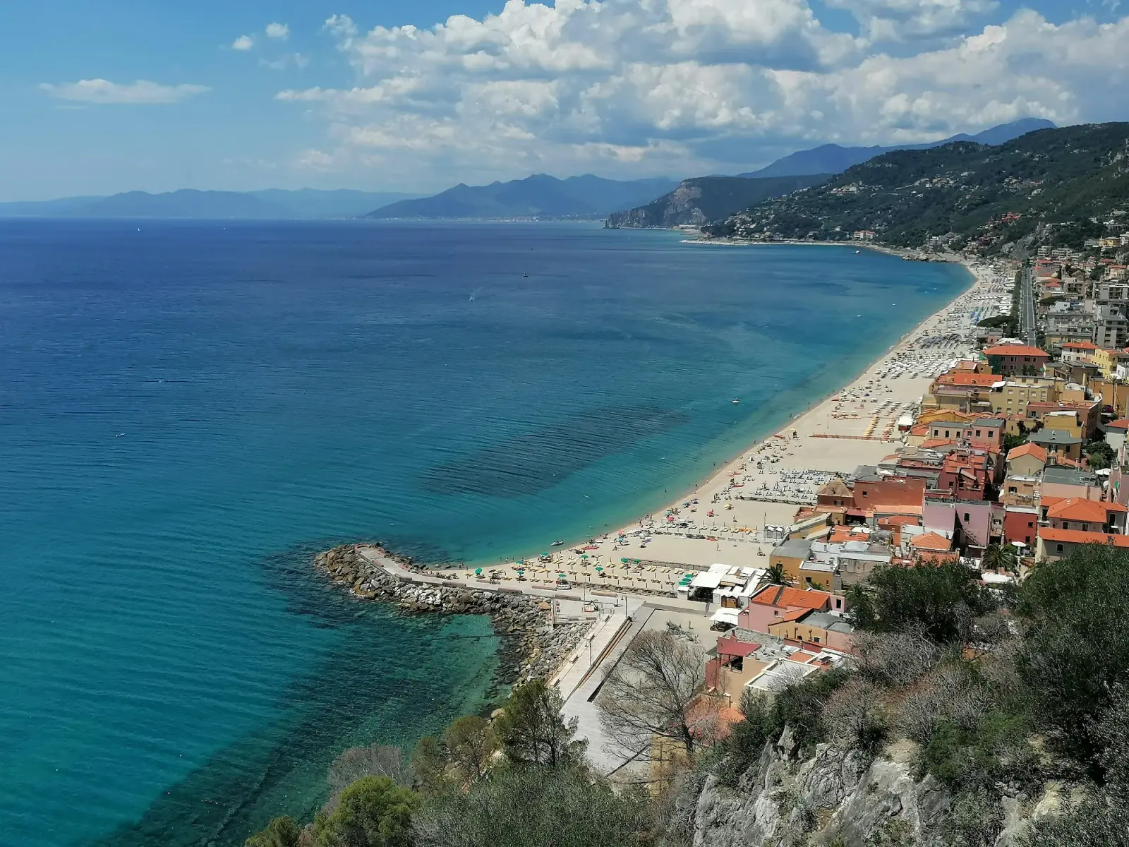 Il borgo saraceno di Varigotti con le case colorate basse affacciate direttamente sulla spiaggia e il mare della Riviera ligure di ponente